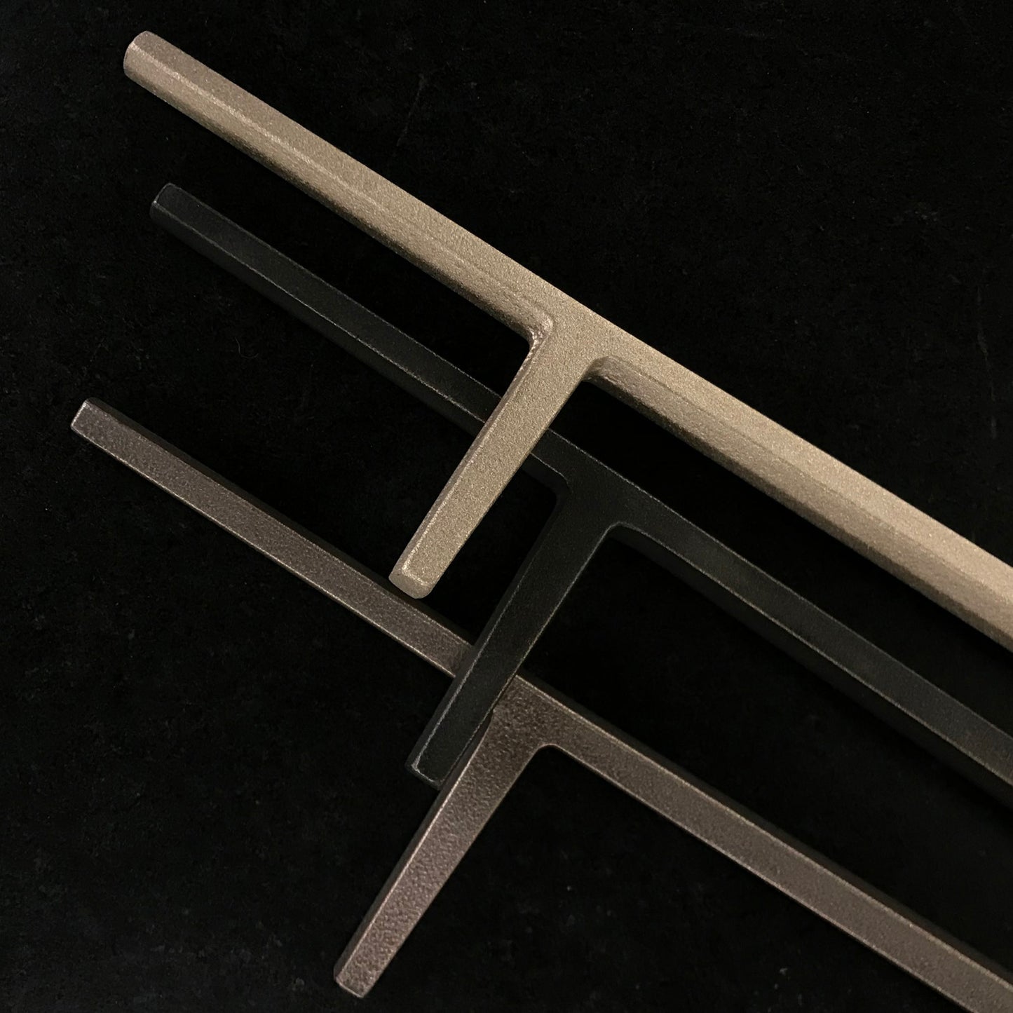 Three patina offerings for bronze shown on a Seru Truex fireplace poker.
